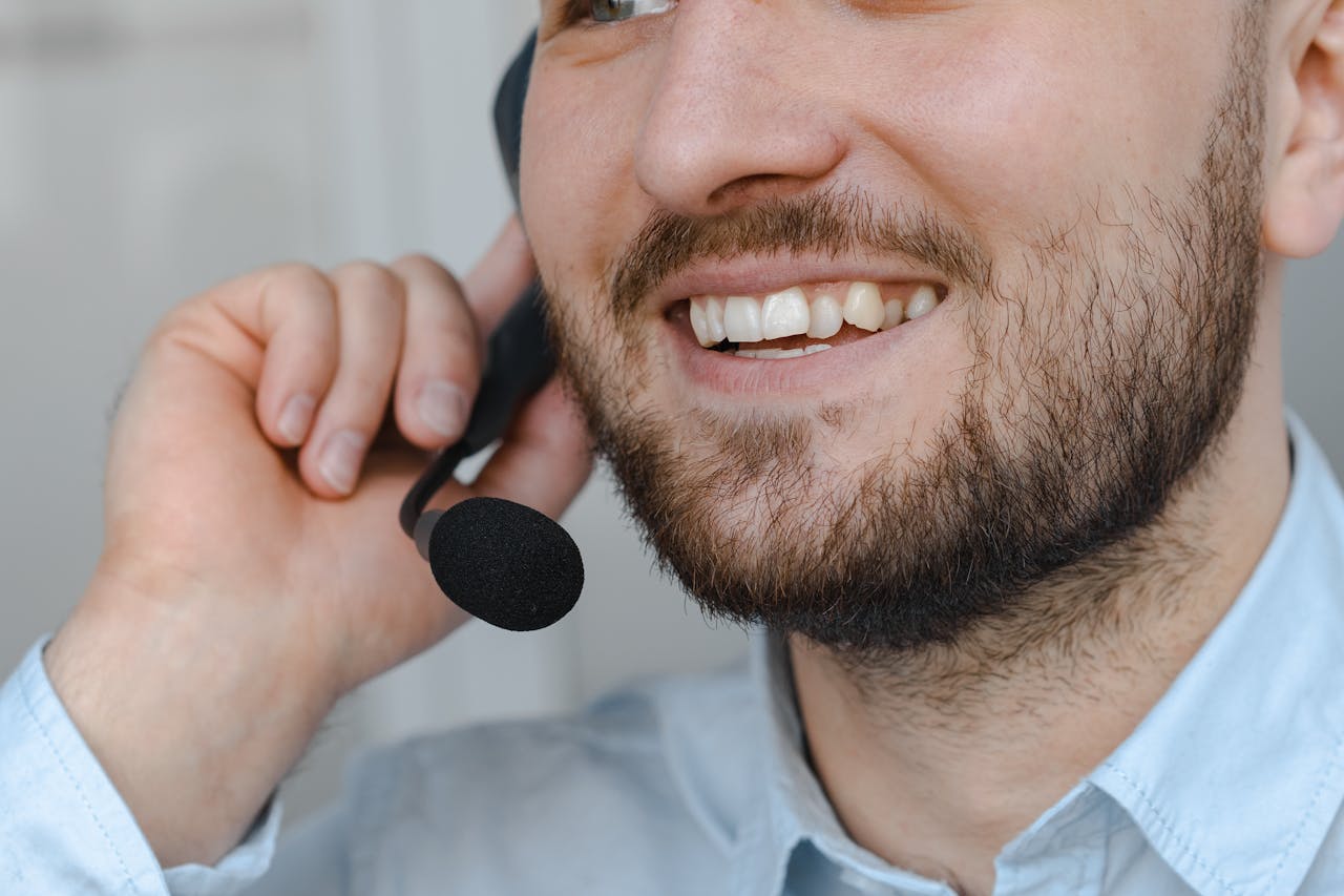 about-04 Close-up of a smiling customer support agent wearing a headset microphone.